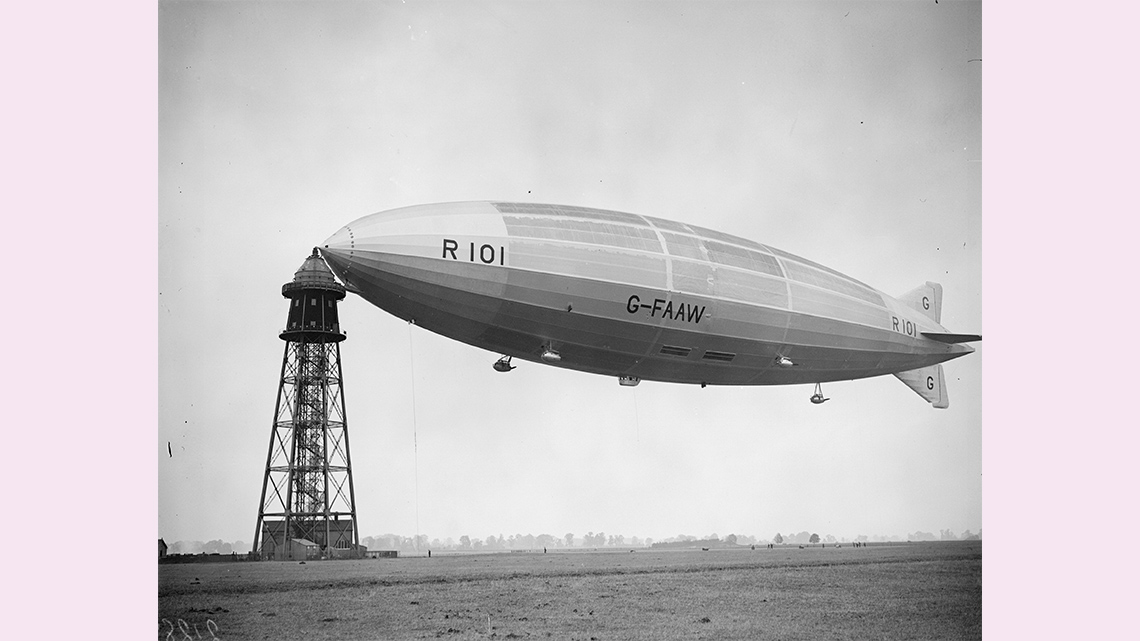 Air ship, or blimp, docked to a control tower.