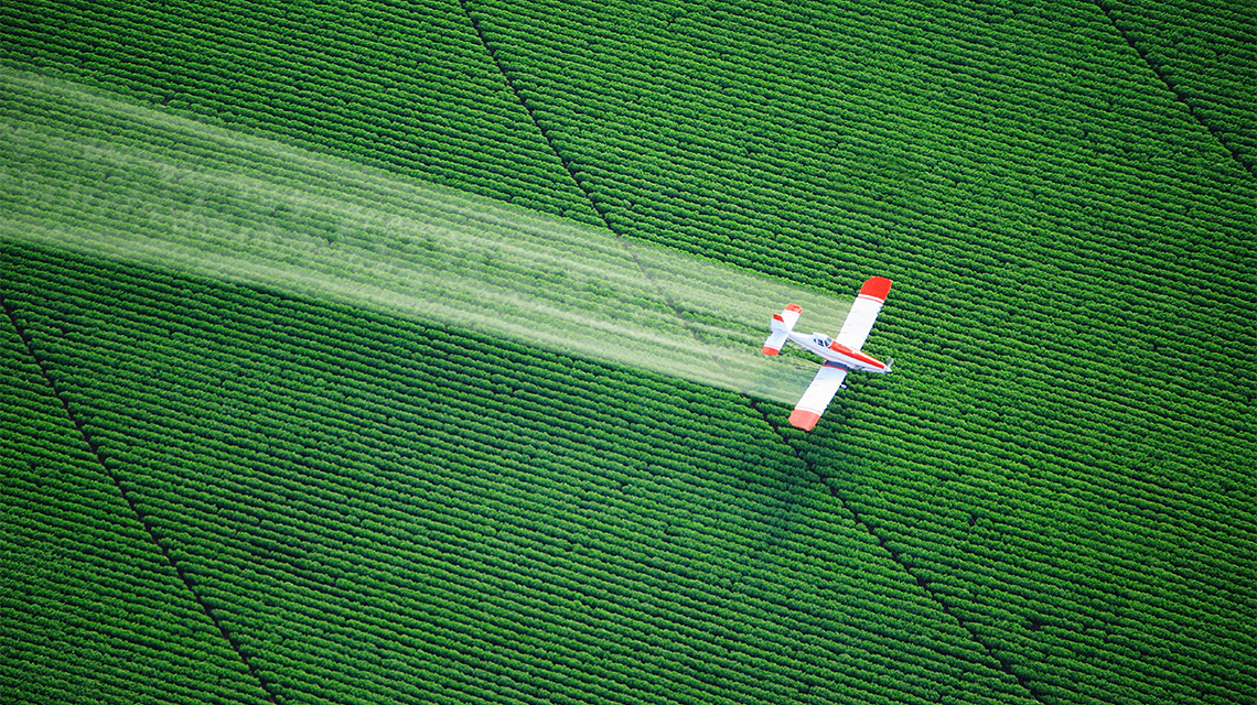 A plane crop dusting a field.