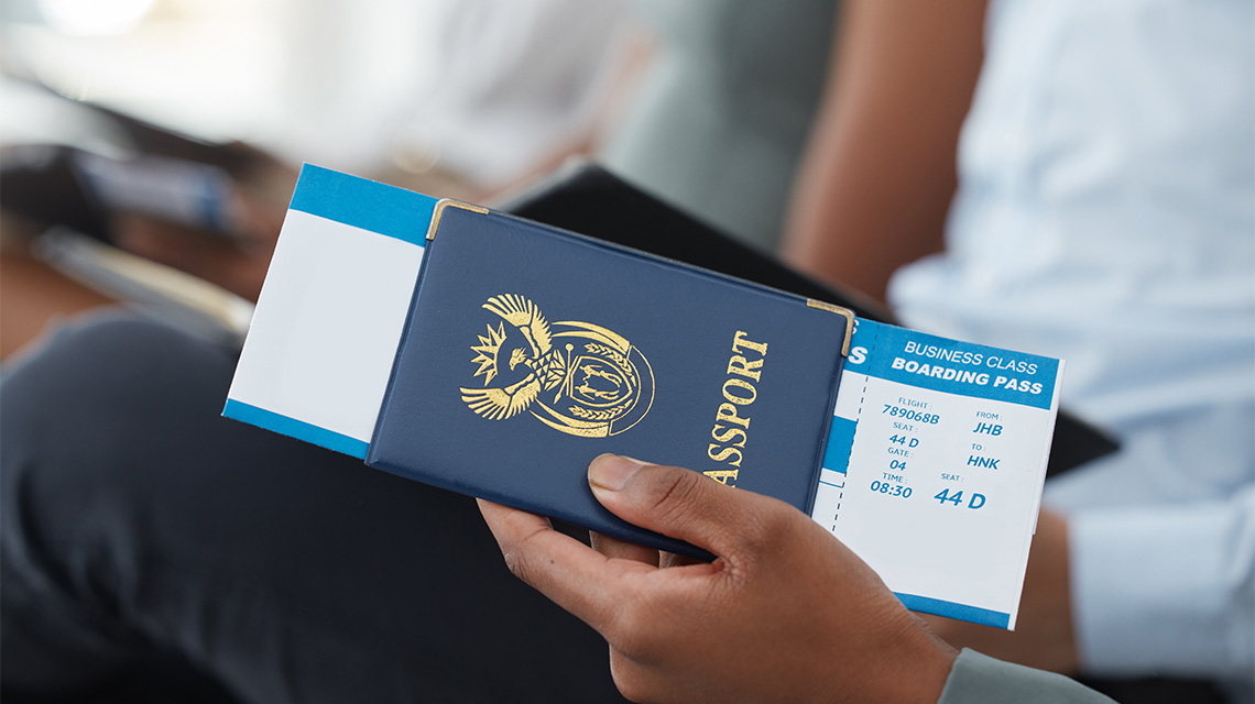 A person holding a passport and a boarding pass.