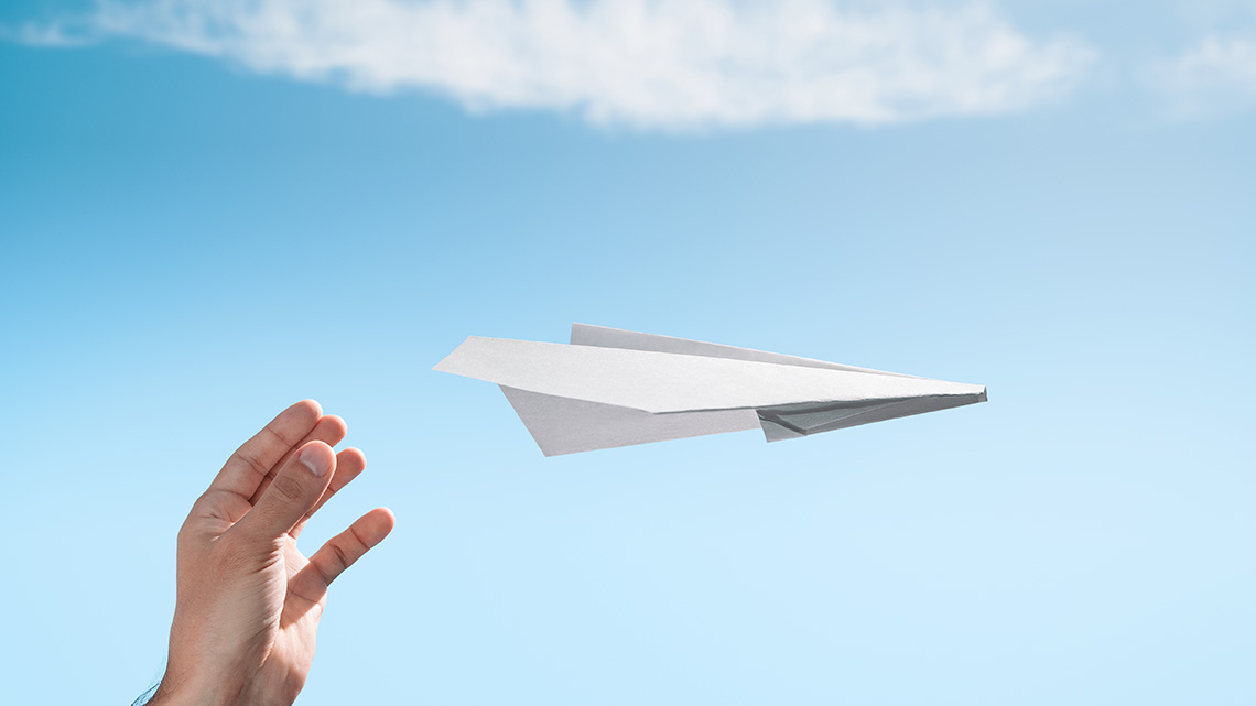 Paper airplane flying in the air.