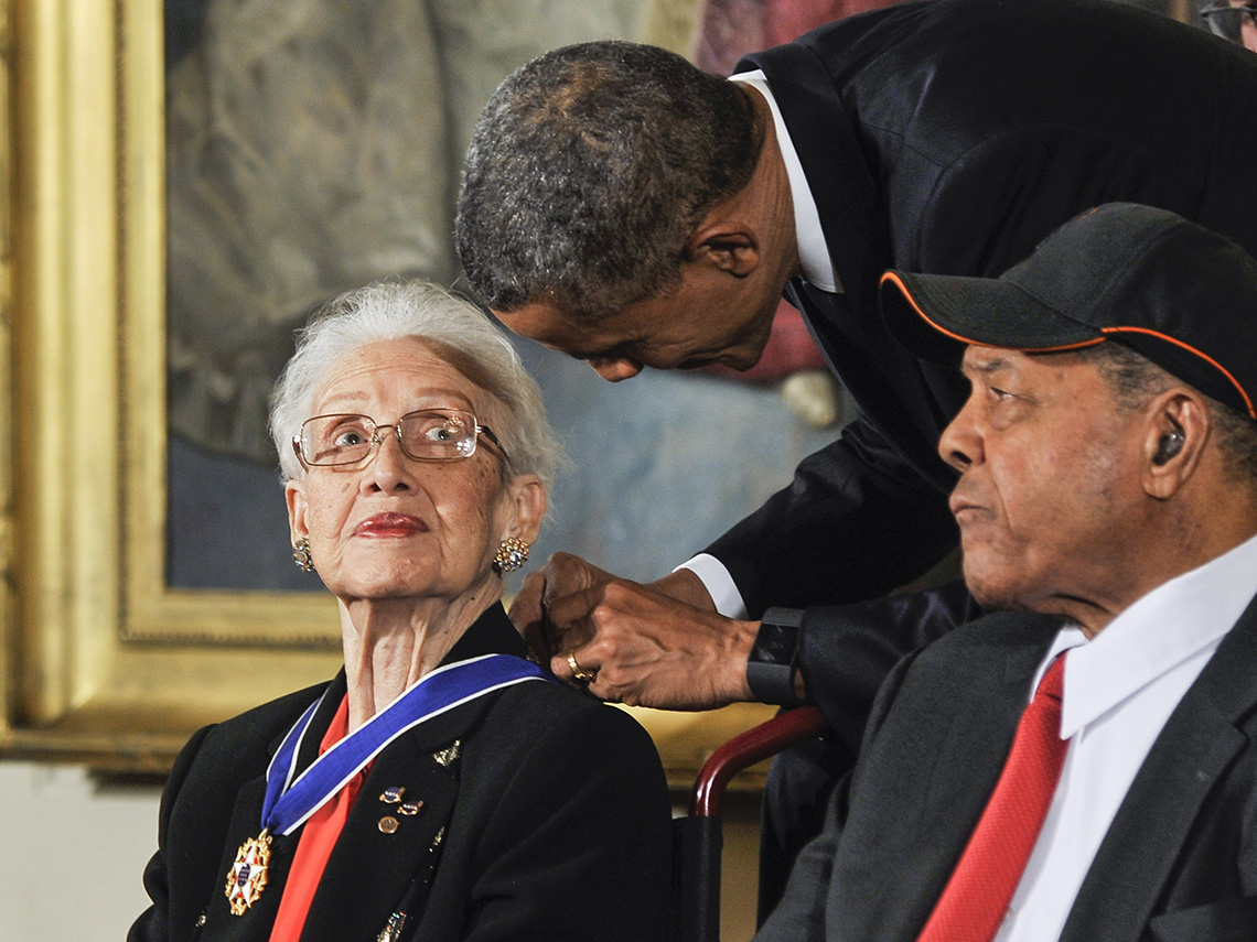 A photo of Katherine Johnson with President Barack Obama. She is wearing a medal around her neck.
