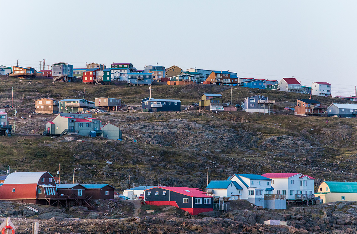 Colourful houses line the side of a rocky hill in Iqaluit, Nunavut.
