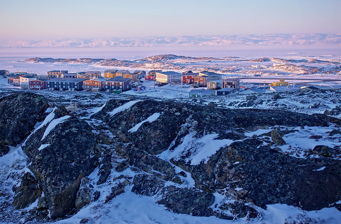 Colourful houses on top of rocky hills and snowy cliffs in Iqaluit, Nunavut.