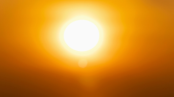 The sun in the sky. It is bright yellow.