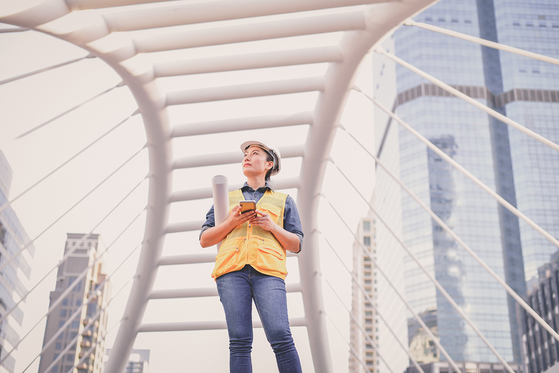 A person standing on a suspension bridge.