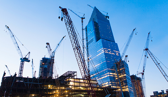 Buildings surrounded by construction cranes.