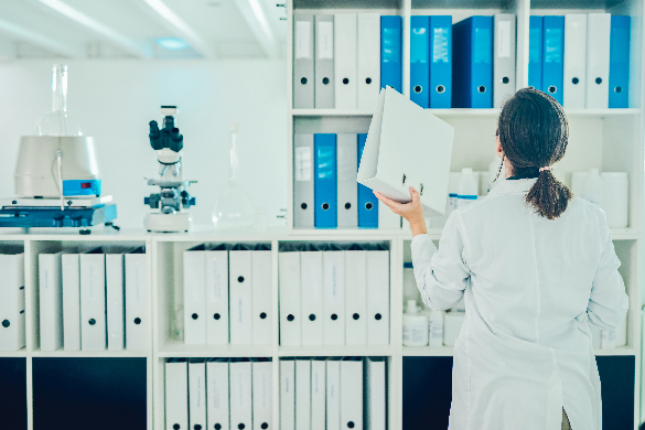 A scientist reviewing files on a shelf.