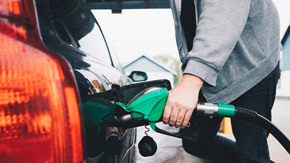 A person filling their car with gasoline.