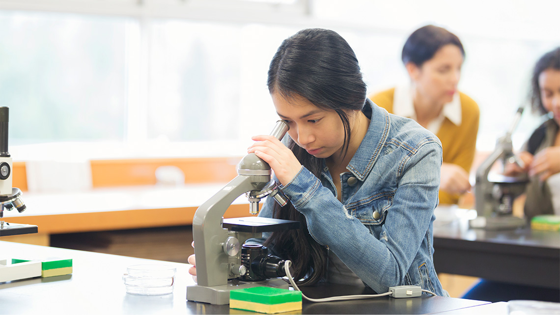 A student using a microscope to examine cells