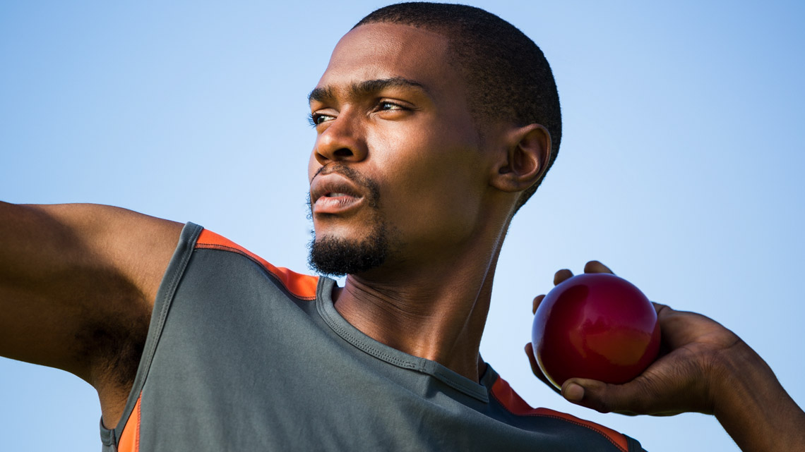 Athlete raising arms to throw a ball.