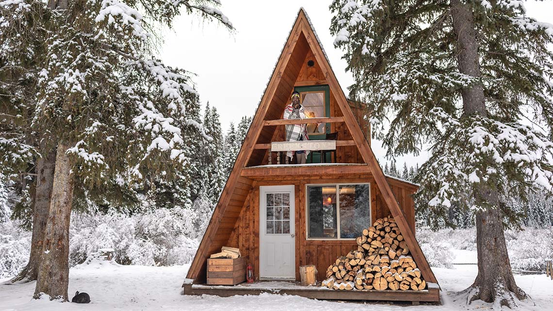 A small home made from wood with glass windows and doors