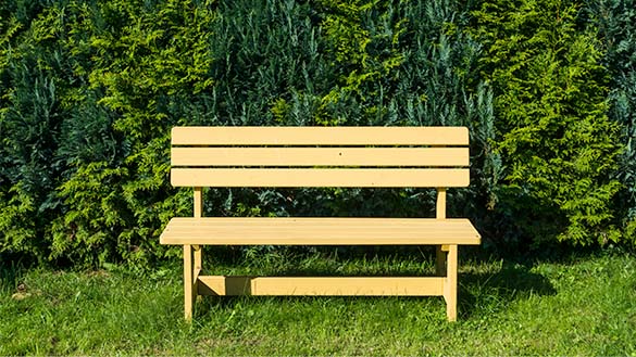 The bench is made of wood planks put together to create a seat, legs, and a back.