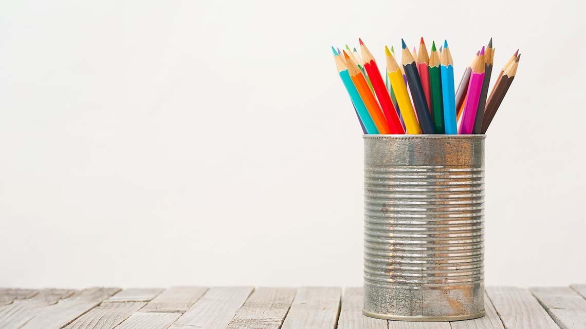 A tin can filled with colourful pencil crayons.