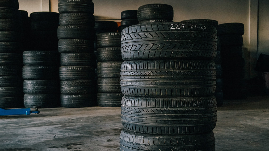 Tires in stacks against a wall.
