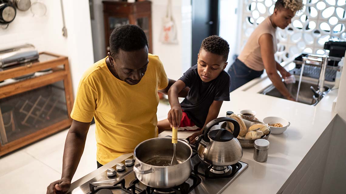 A learner is cooking using water while an adult supervises.