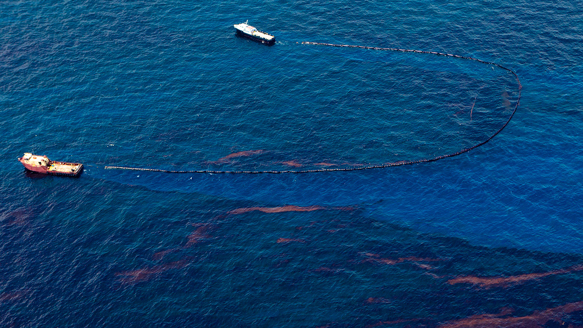 Boats use nets to clean oil off of the surface of the water.