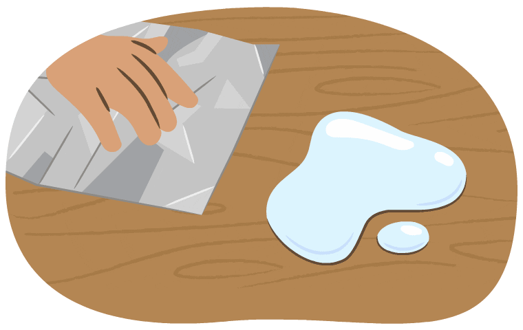 A hand uses aluminum foil to try to wipe up water.