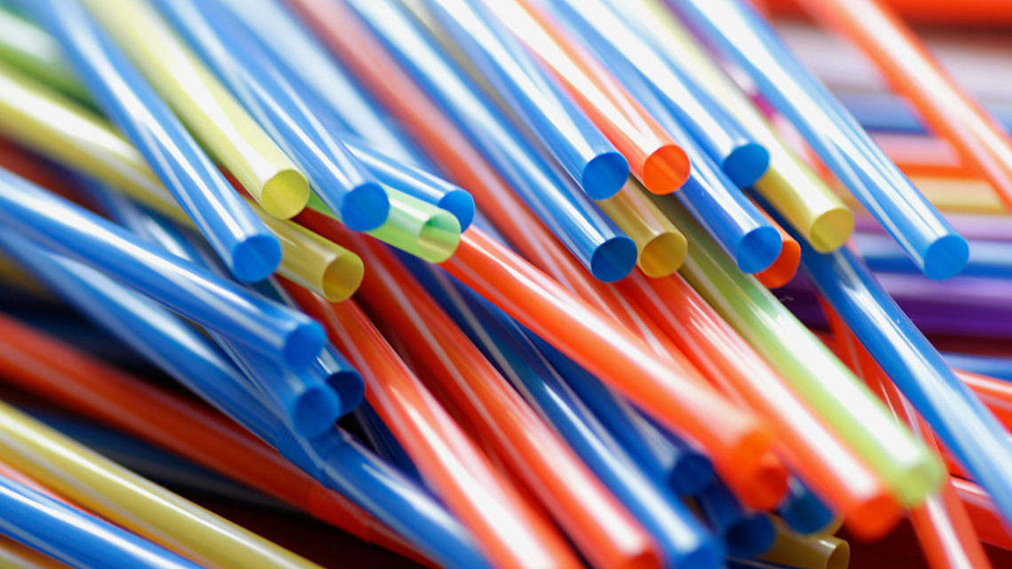 A pile of plastic drinking straws in different colours.