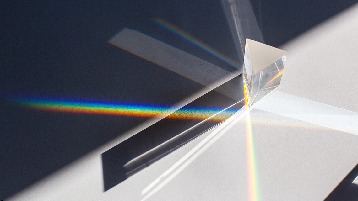 A glass prism with light shining onto it.