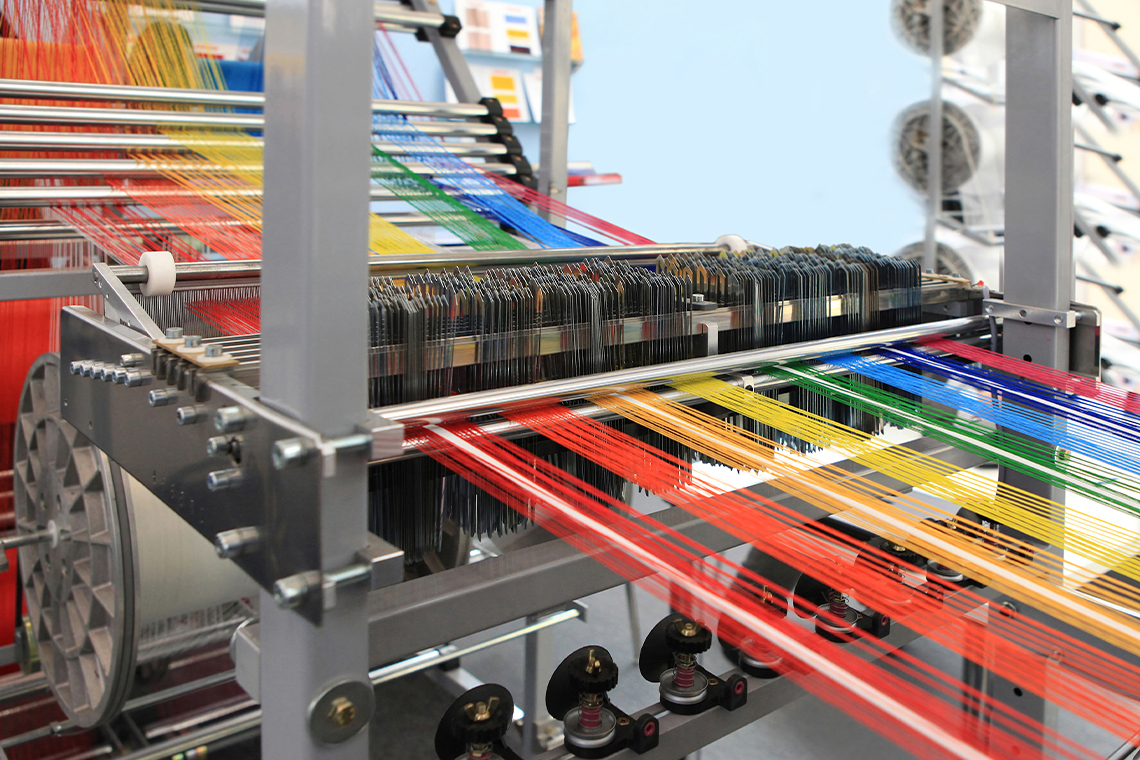 Multi-coloured yarn spinning through a textile machine.