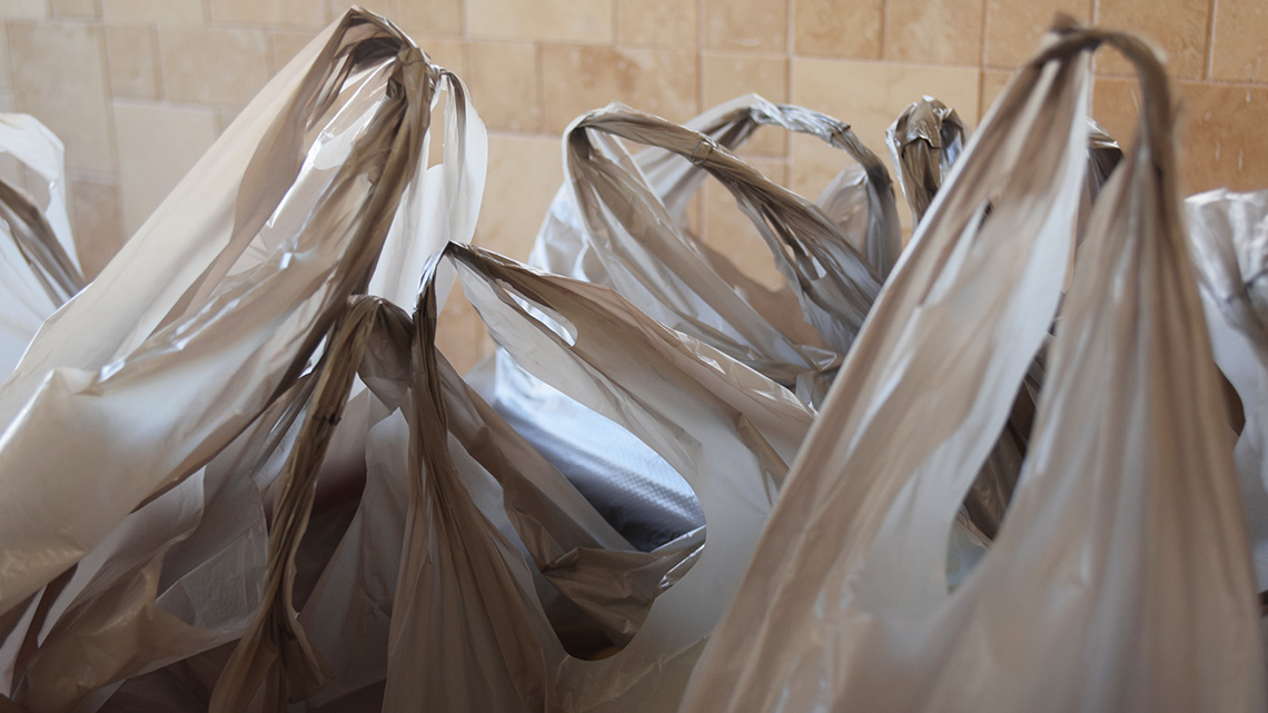 Plastic shopping bags that are placed on the floor.