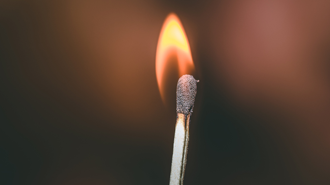 A burning match produces a flame.