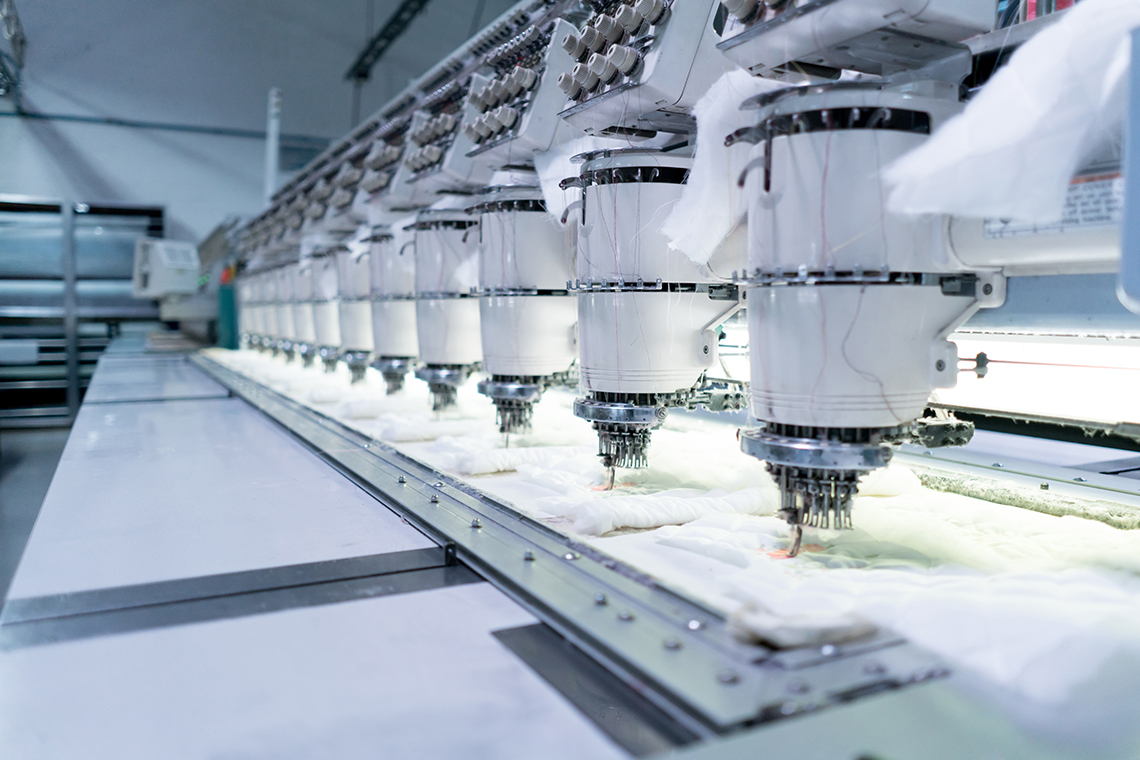 A row of embroidery machines at a clothing factory