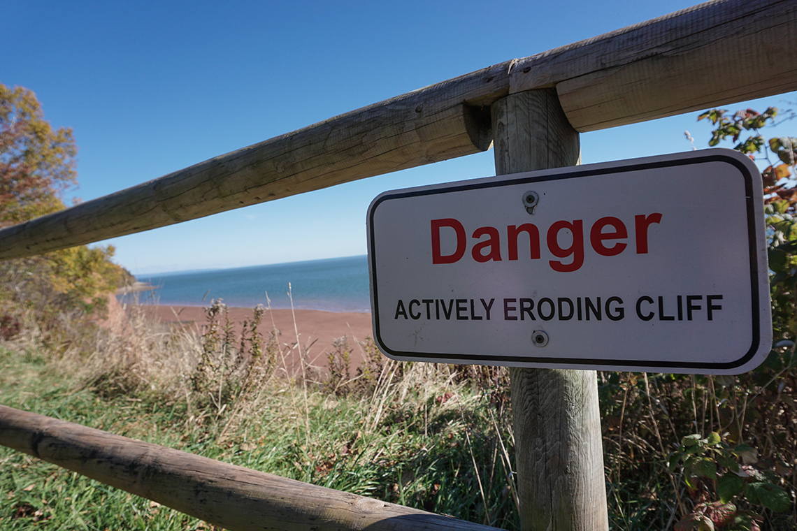 Eroding cliff A sign at the top of a shore-side cliff that says “Danger: Actively eroding cliff”