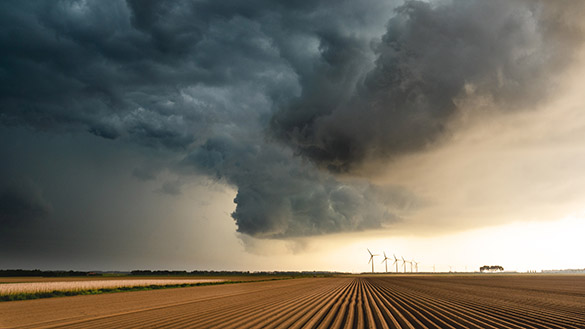 Dark clouds over a dry farm field