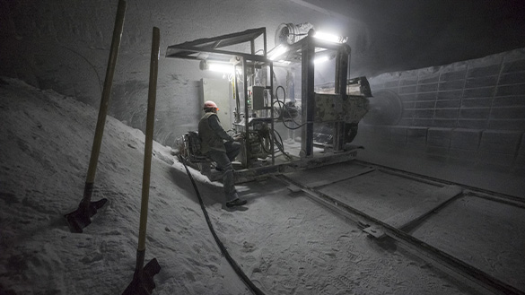 A person using a driller while in an underground mine.
