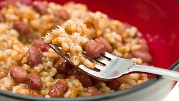 A fork holding a scoop of rice and beans.