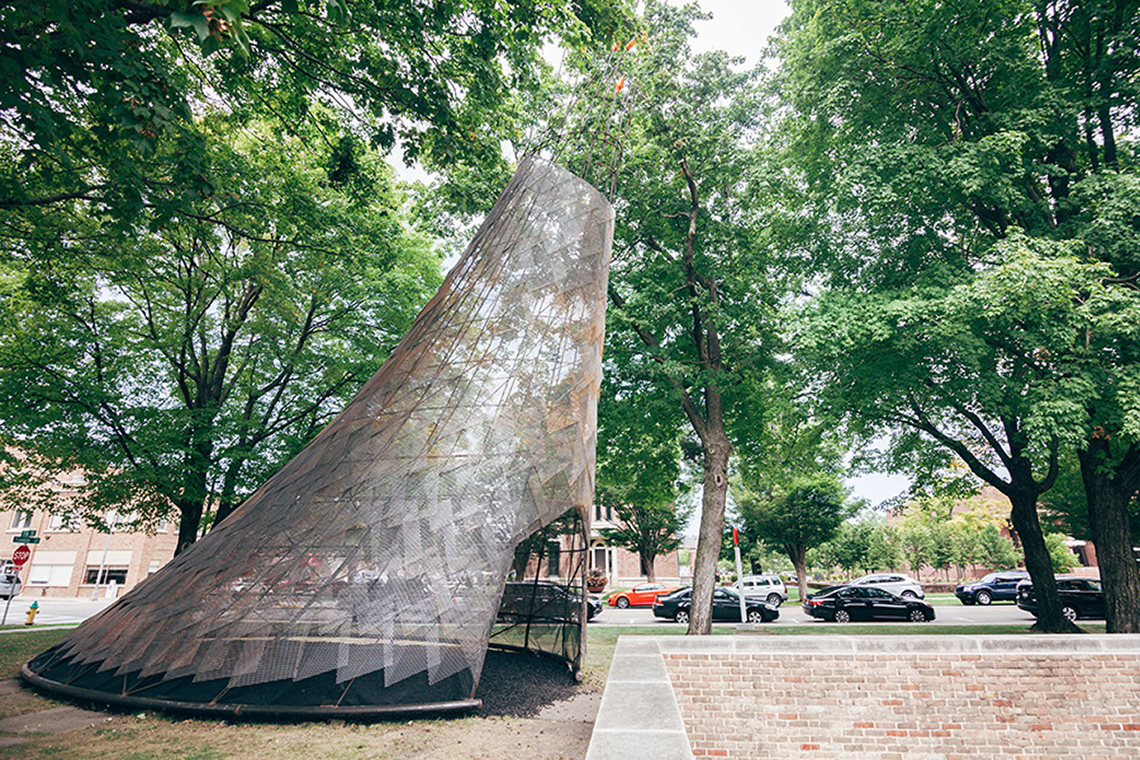 Wiikiaami is a welded steel wigwam surrounded by trees.