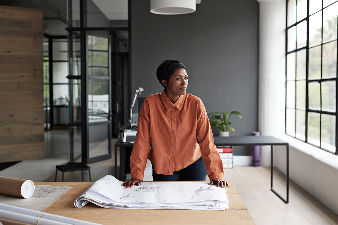 An architect standing behind a desk.