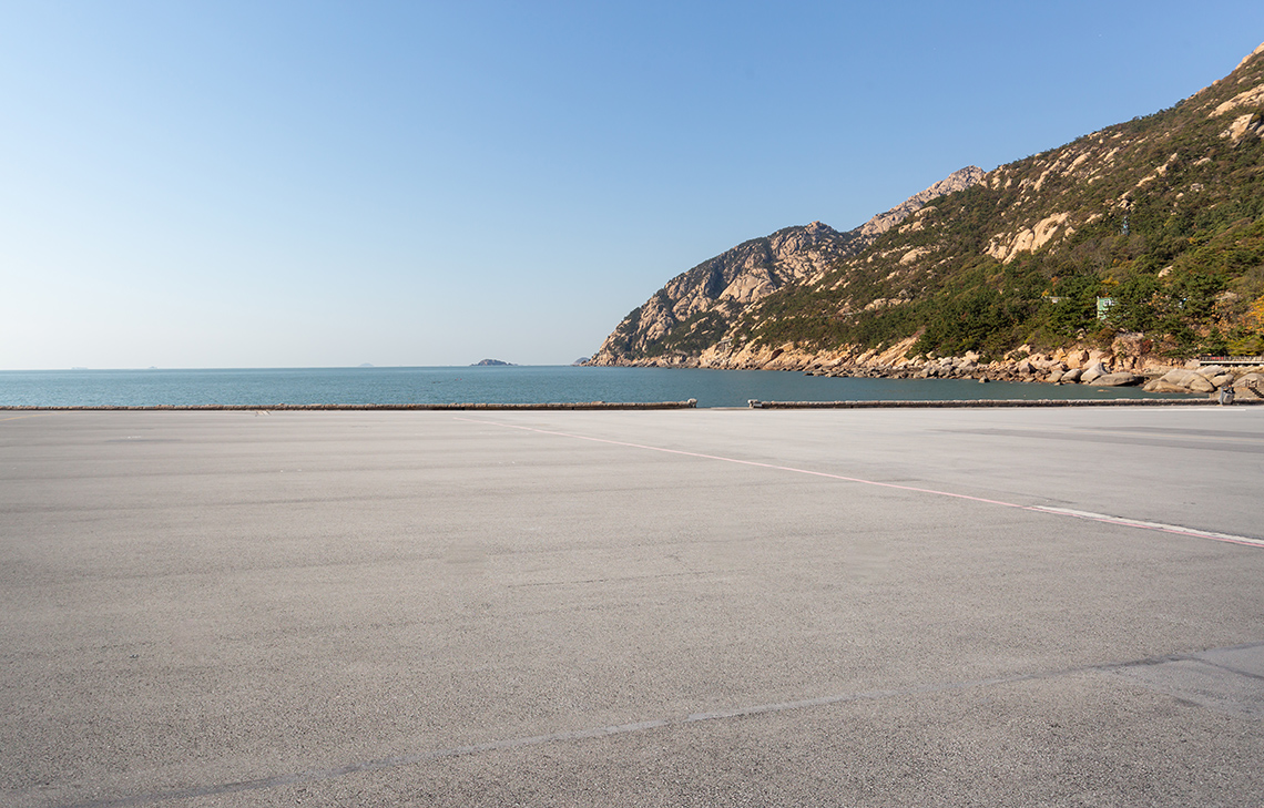 A parking lot next to a body of water.