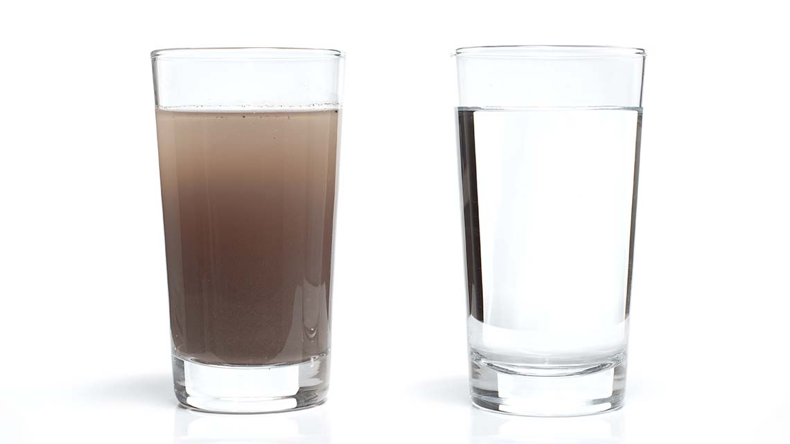 Two glasses of water, one filled with dirty water, the other filled with clean water.
