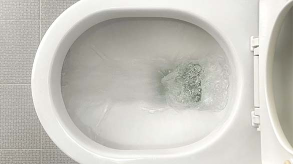 Ceramic toilet with the seat raised is being flushed.