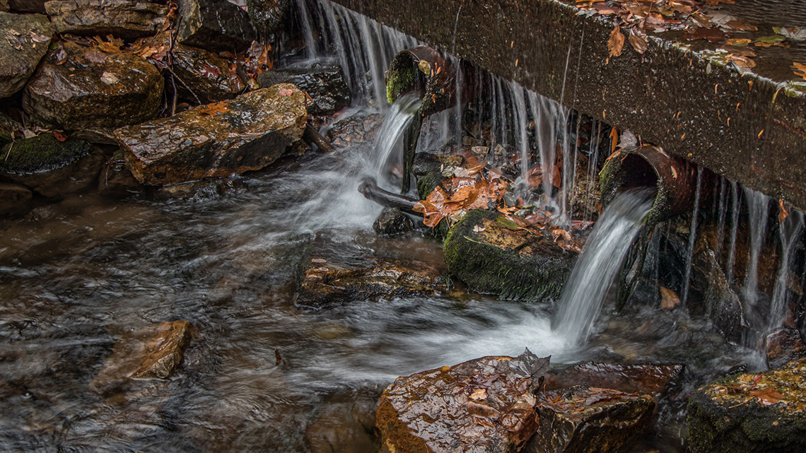 Close-up view of a storm sewer draining into a waterway.