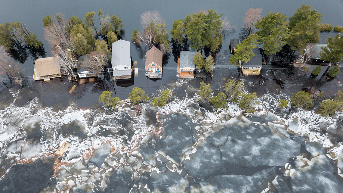 An aerial view of a flooded street of houses.