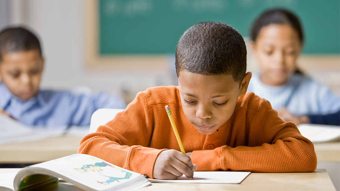 Child taking notes, writing in a notebook