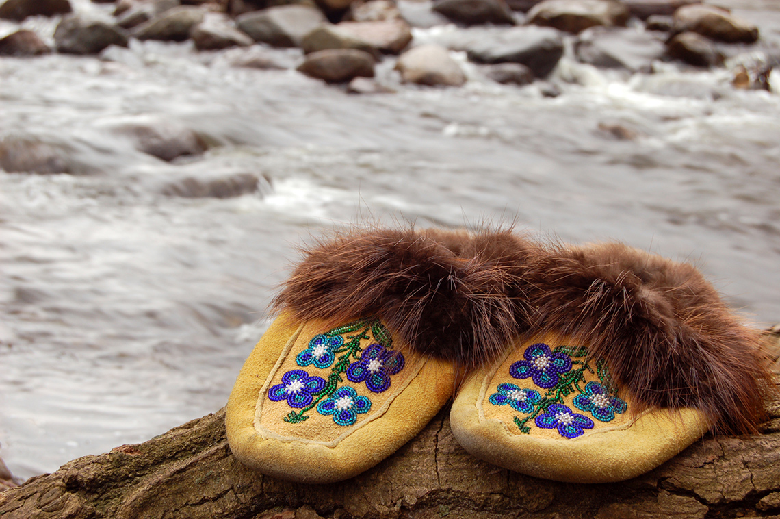Moccasins line with fur and designed with flower beadwork.