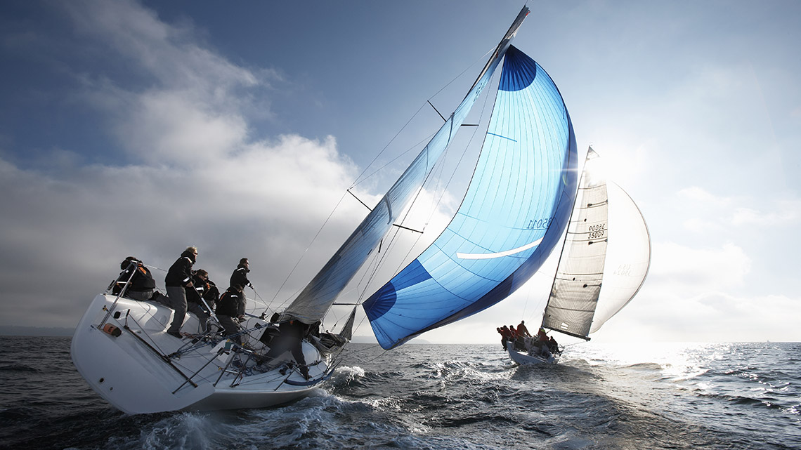 A sailboat with wind in its sails pushing it through the water.