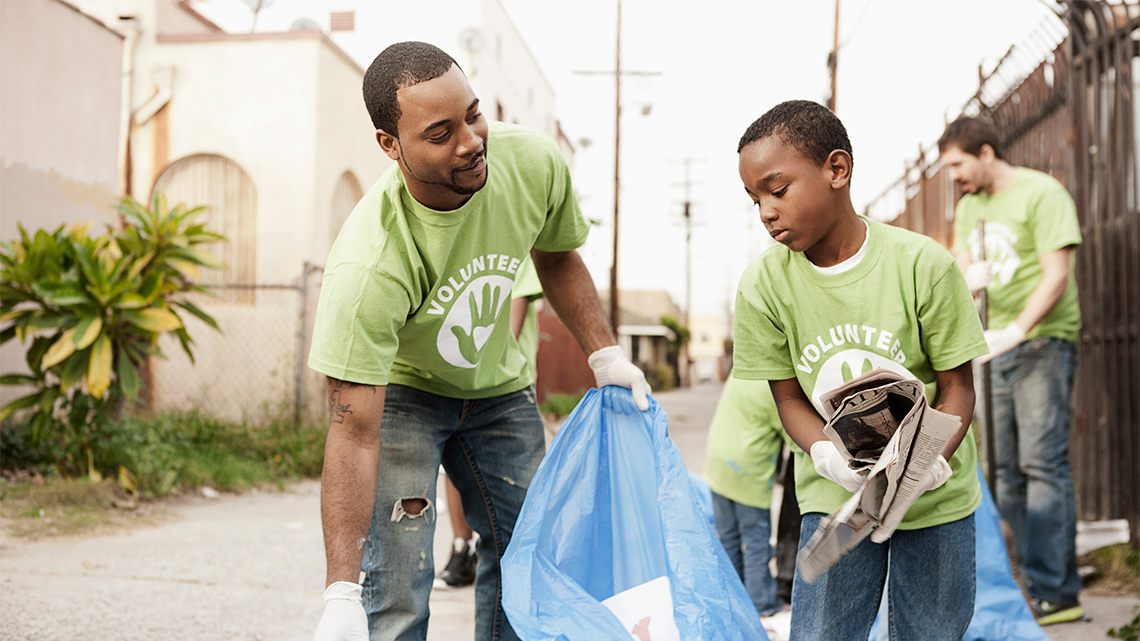 People are working together to pick up litter outside and sort it into recycling.