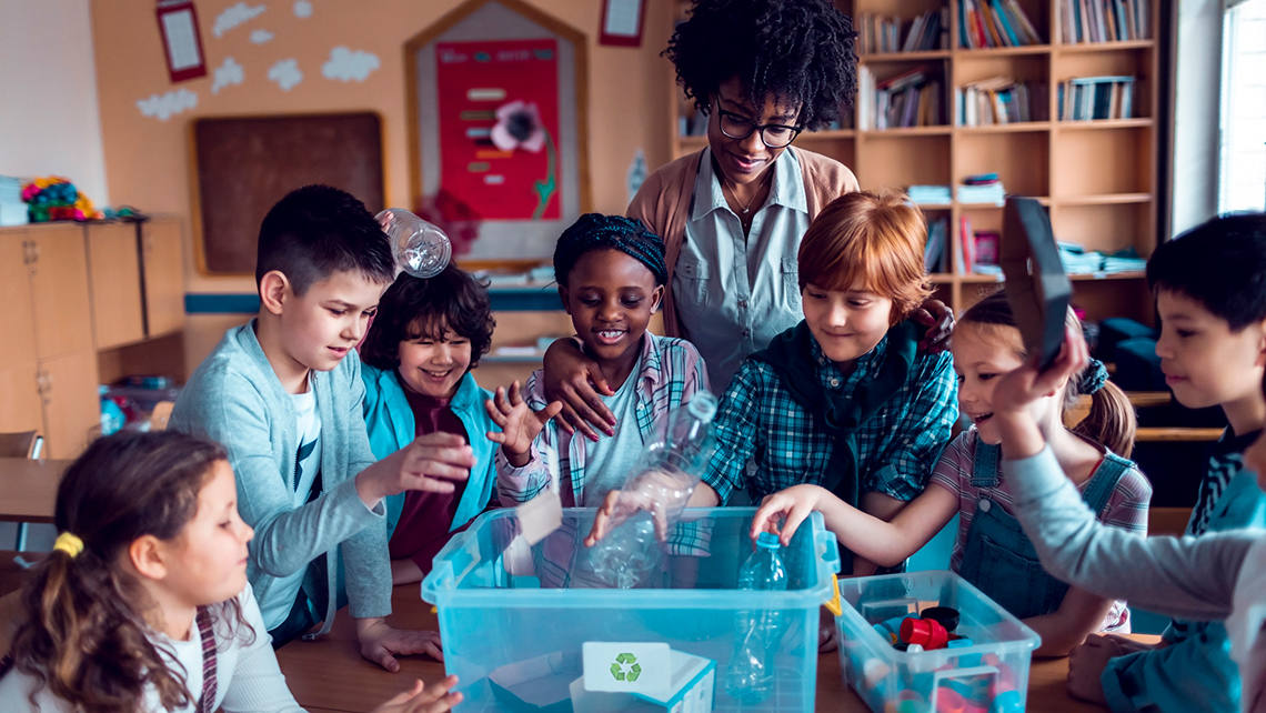 A group of people are sorting items into recycling or garbage bins.