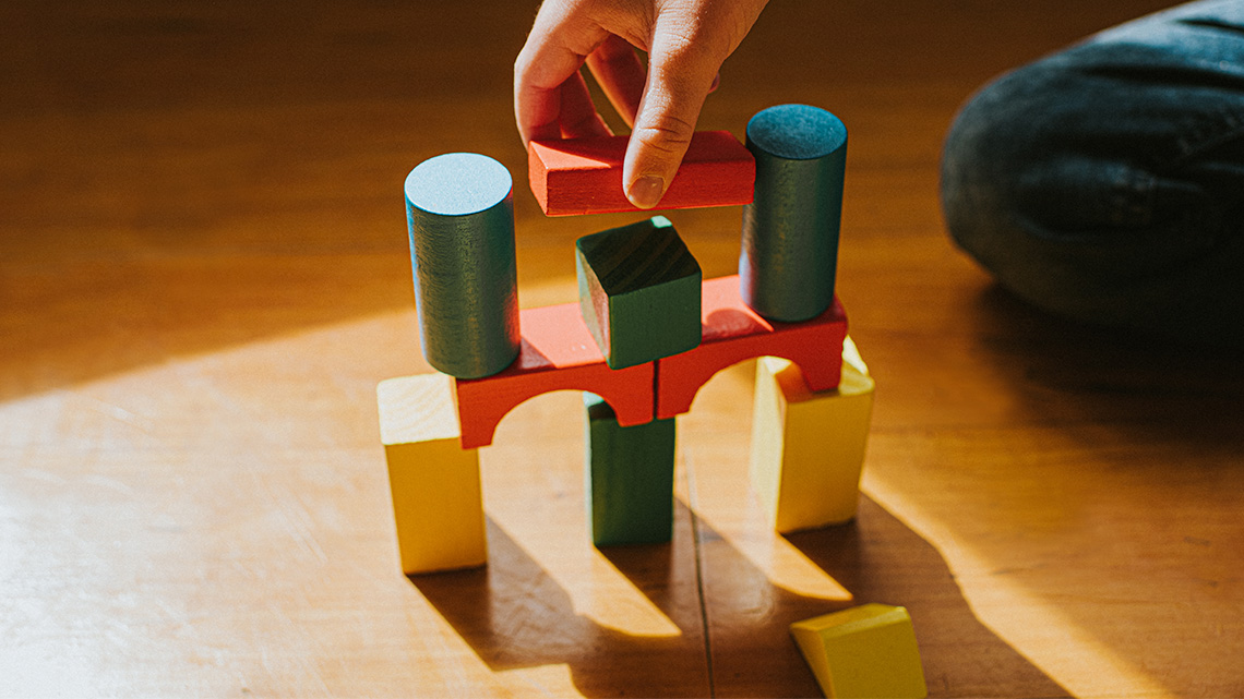 A toy bridge made out of wooden blocks.