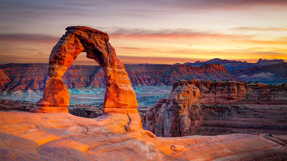 Rocks forming a natural arch over a large canyon.