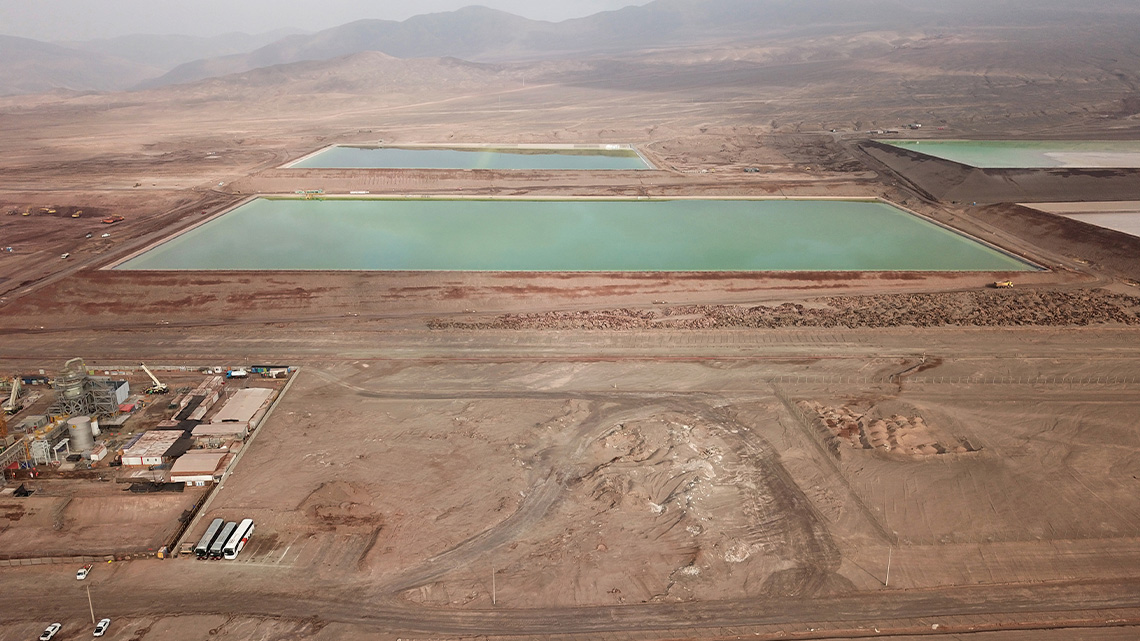 Rectangular lithium pools filled with green water and surrounded by dry ground.