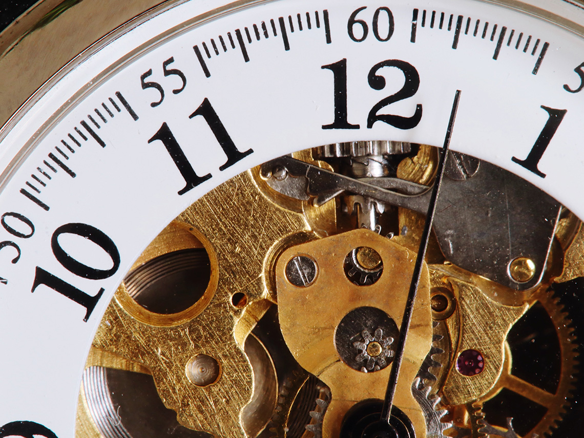 An analog (non-digital) clock with visible gears 