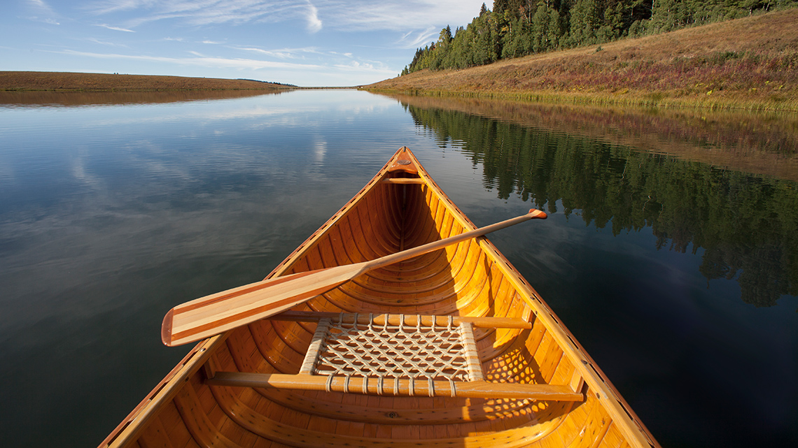 A wooden canoe on the water.