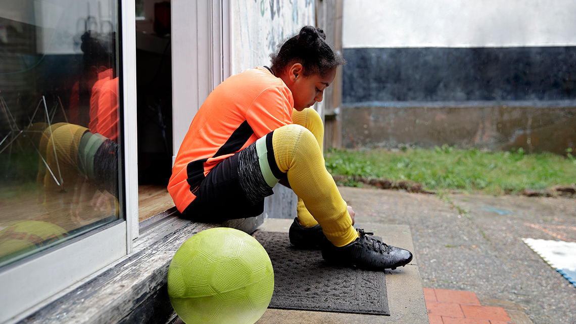 Soccer player tying up their cleats