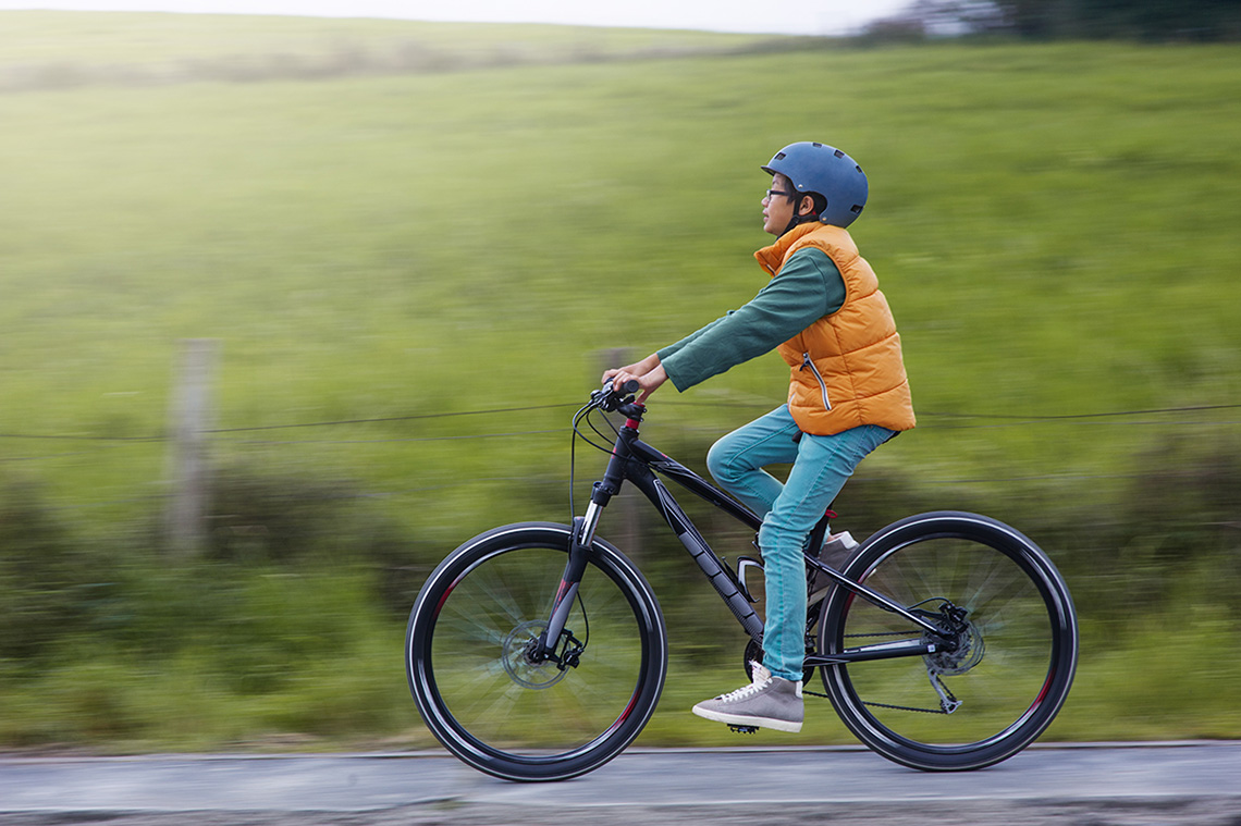 Person riding a bicycle. They are wearing a helmet.
